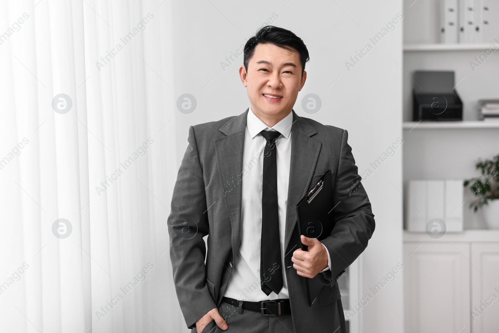 Photo of Portrait of happy notary with clipboard indoors