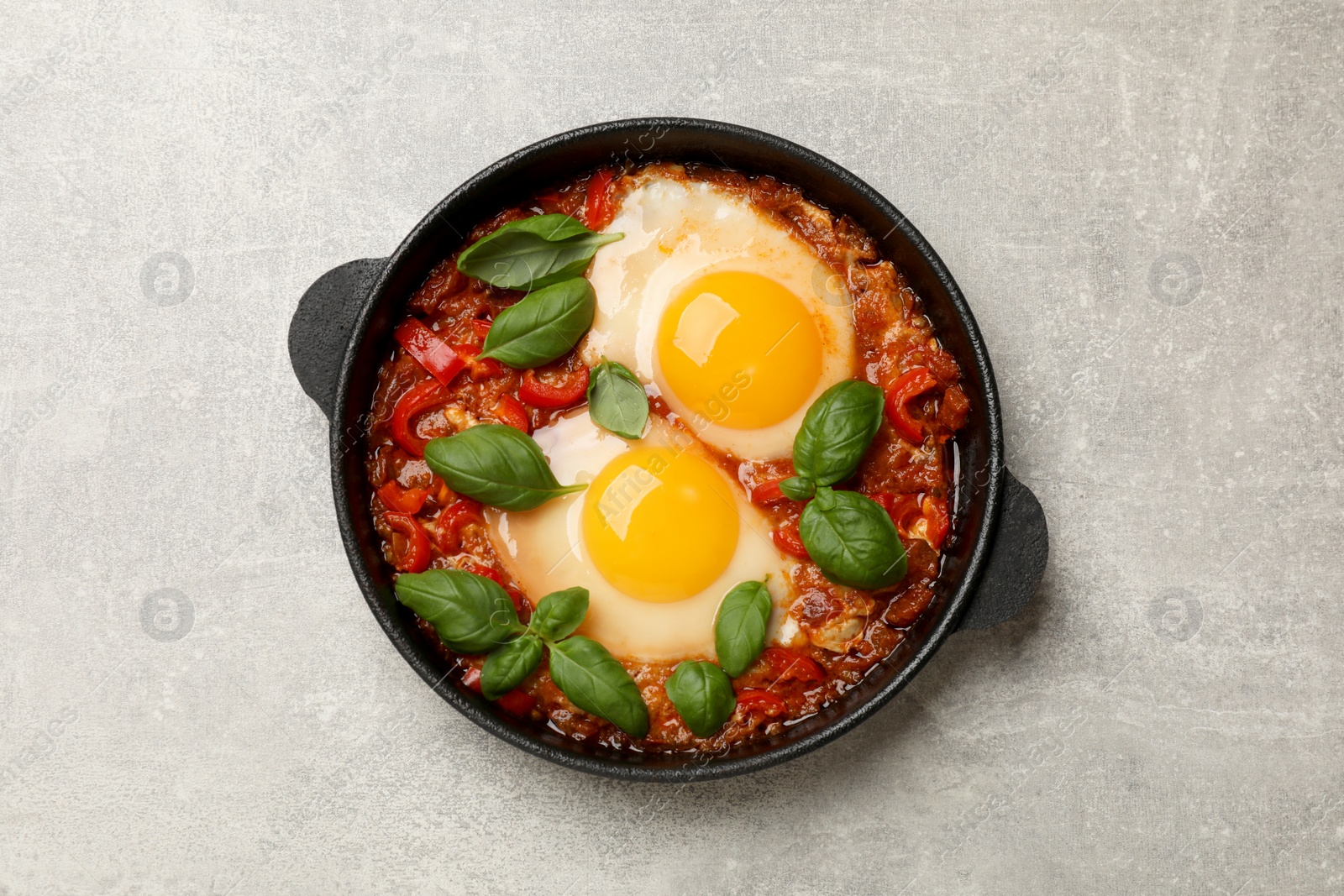 Photo of Delicious Shakshuka on light grey table, top view