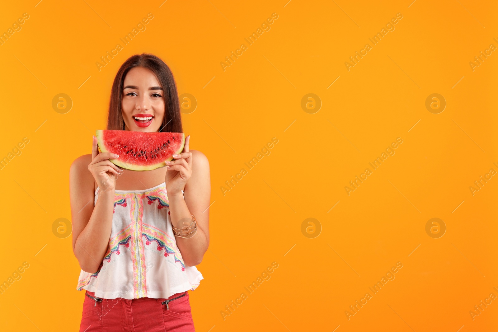 Photo of Beautiful young woman posing with watermelon on color background