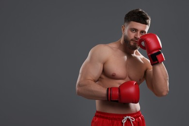 Man in boxing gloves on grey background. Space for text