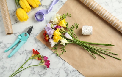Photo of Flat lay composition with freesia flowers on table
