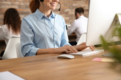 Photo of Technical support operator with headset at workplace