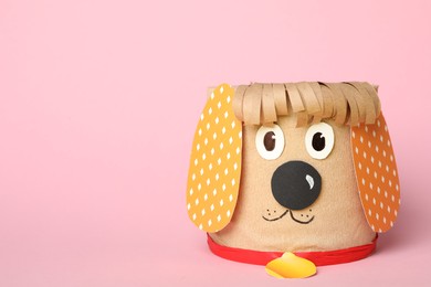 Photo of Toy dog made of toilet paper roll on pink background. Space for text