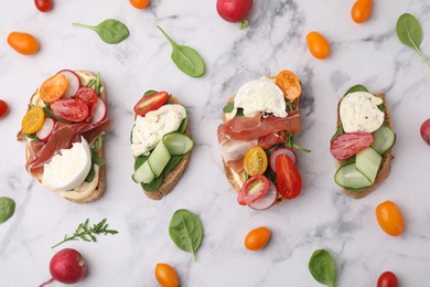 Photo of Delicious burrata sandwiches served on white marble table, flat lay
