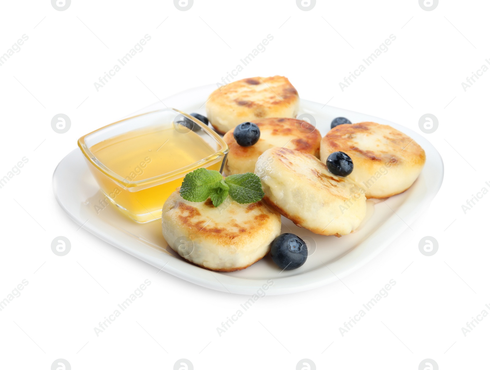 Photo of Delicious cottage cheese pancakes with blueberries, mint and honey isolated on white