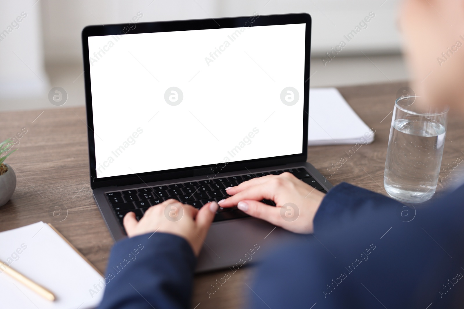 Photo of Woman watching webinar at wooden table in office, closeup