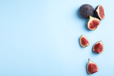 Photo of Delicious ripe figs on light blue background, flat lay. Space for text