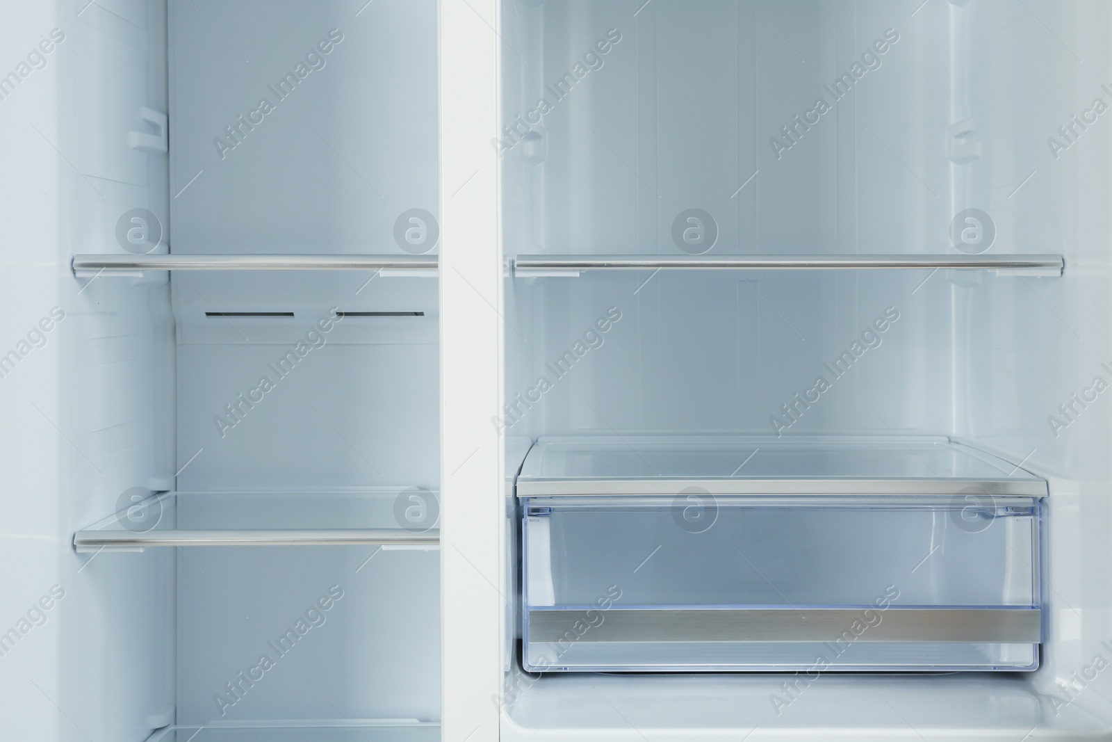 Photo of Shelves of empty modern refrigerator, closeup view