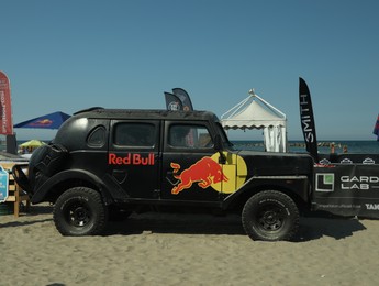 Photo of SENIGALLIA, ITALY - JULY 22, 2022: Red Bull Jeep on beach. Car presentation