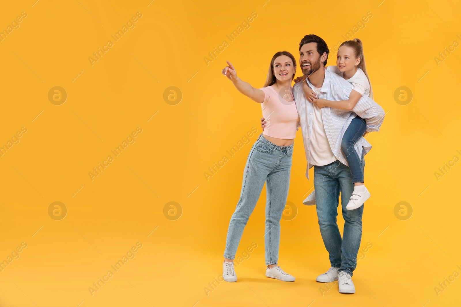 Photo of Happy family on orange background, space for text