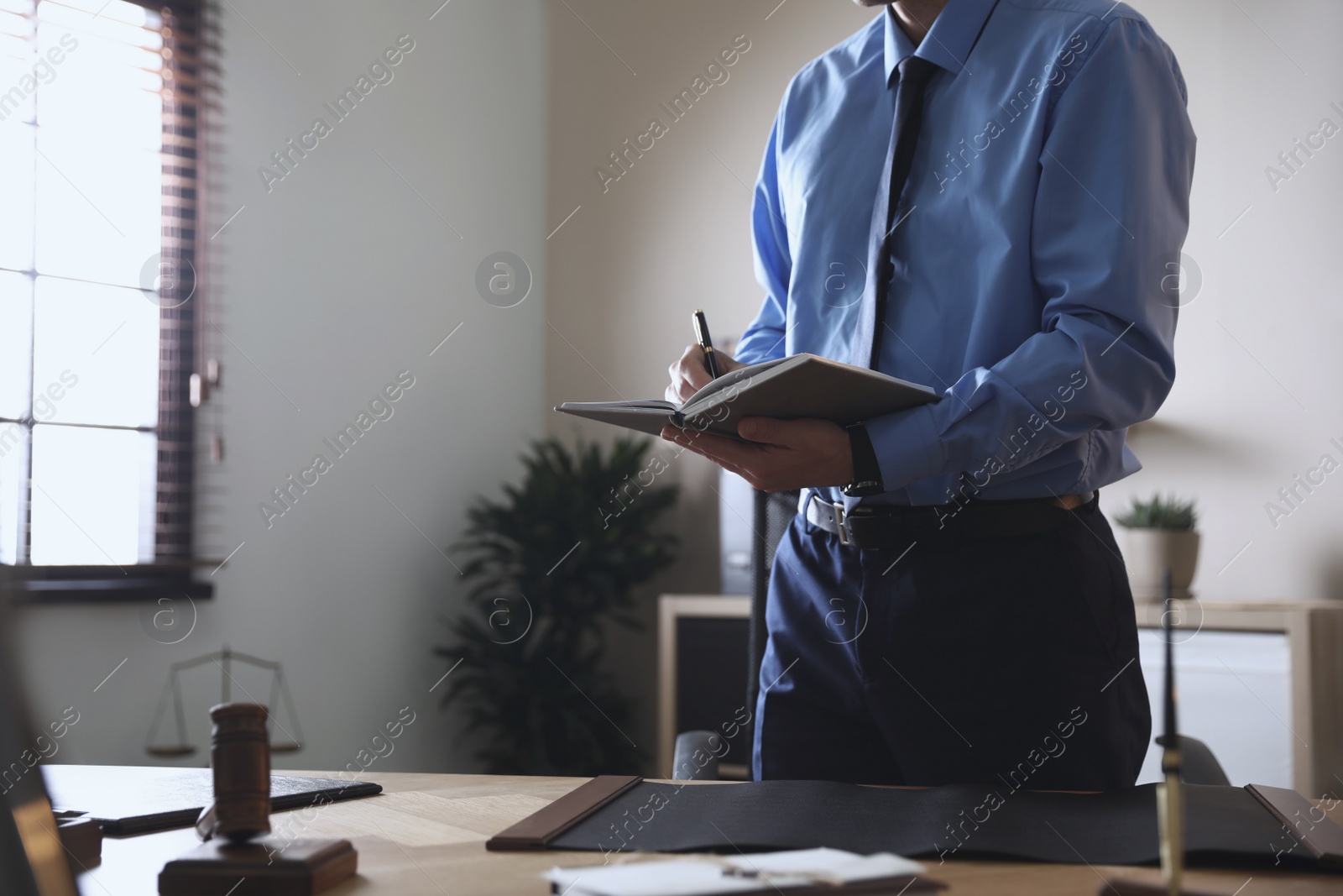 Photo of Male lawyer working at table in office, closeup