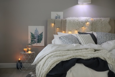 Cozy bedroom interior with warm blanket and cushions