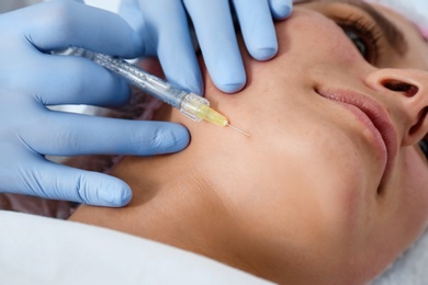 Photo of Woman undergoing face biorevitalization procedure in salon, closeup. Cosmetic treatment