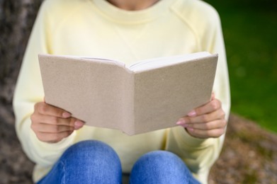 Photo of Woman reading book in park, closeup view