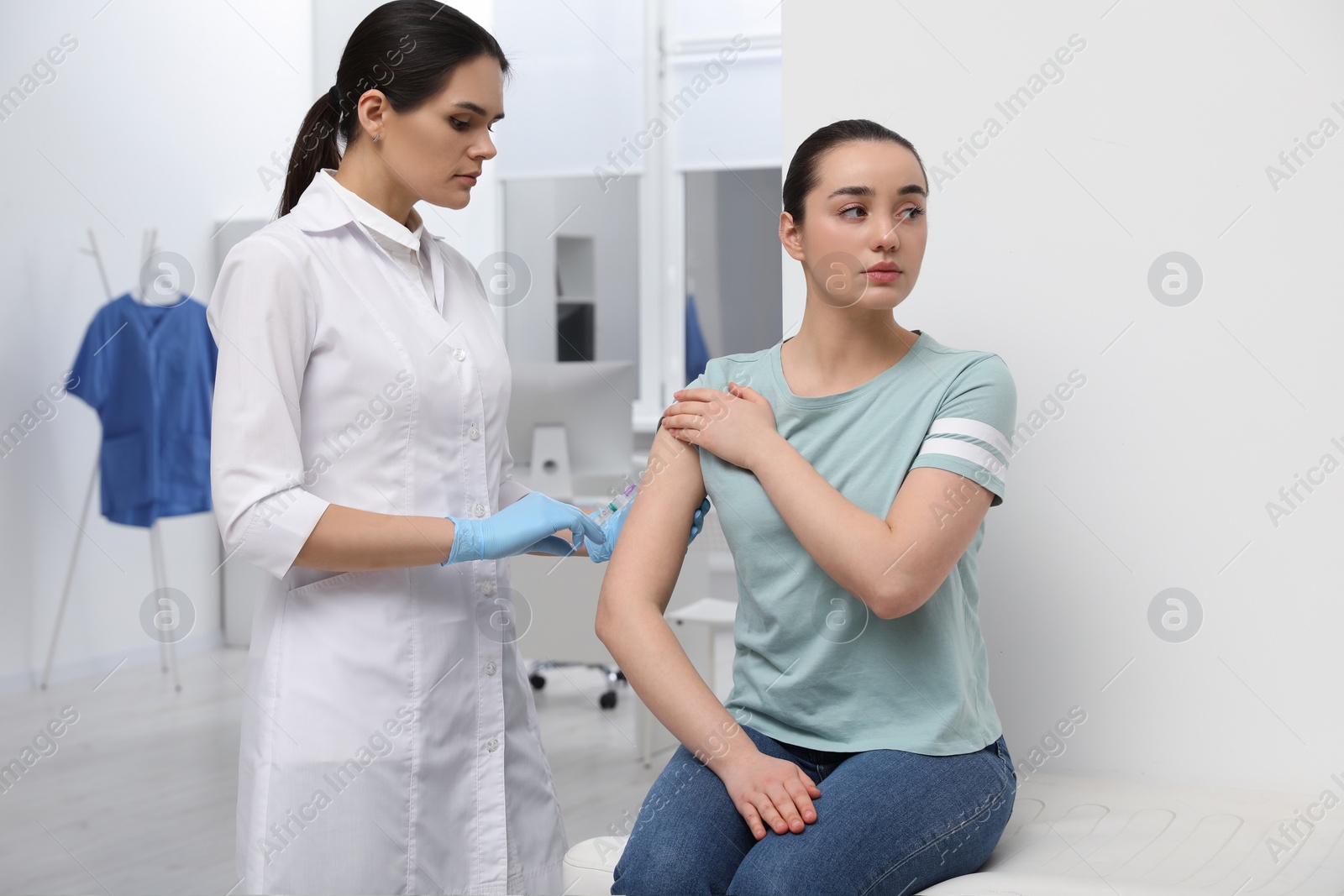 Photo of Doctor giving hepatitis vaccine to patient in clinic