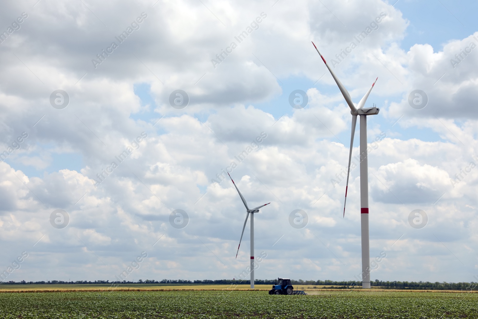 Photo of Modern wind turbines in field on cloudy day. Alternative energy source