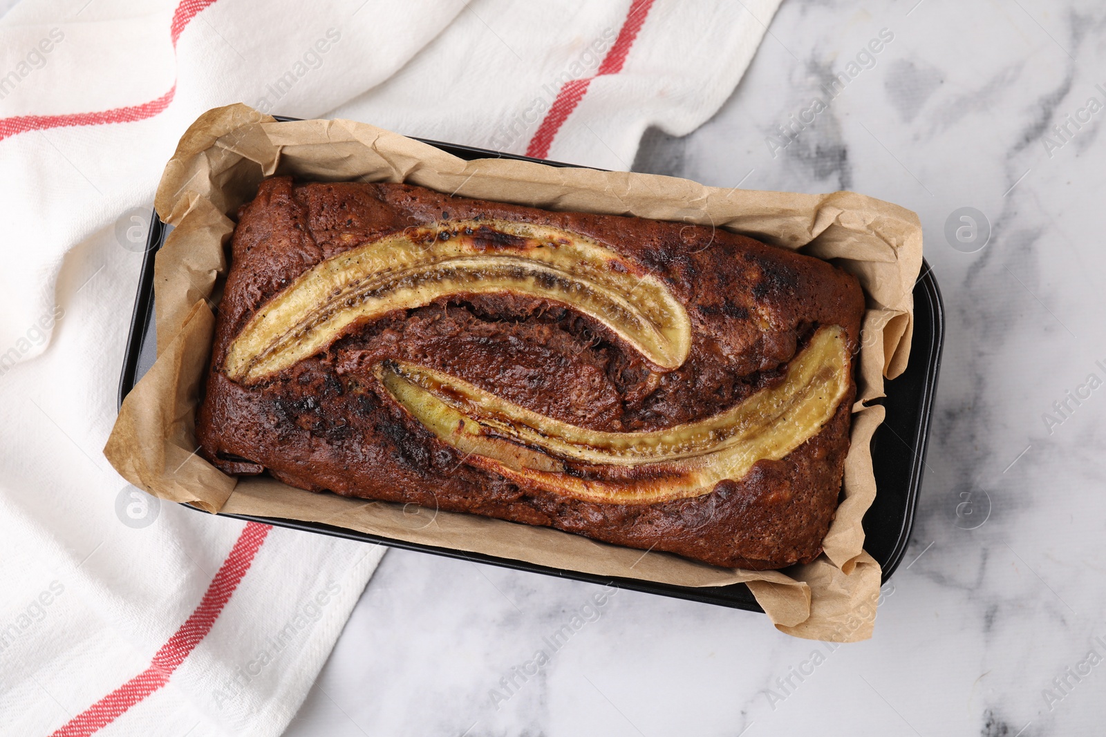 Photo of Delicious banana bread on white marble table, top view