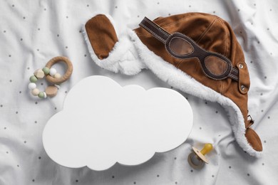 Photo of Flat lay composition with cloud shaped child's night lamp on white fabric
