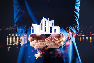 Double exposure of real estate agent with house illustration and night city