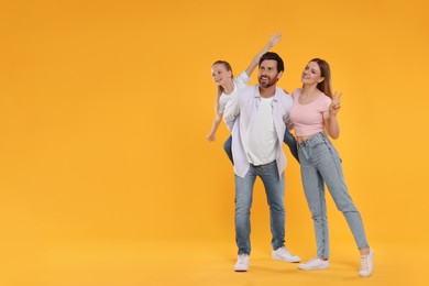 Happy family on orange background, space for text