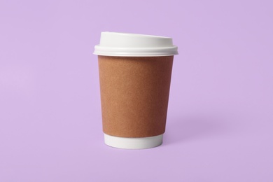 Takeaway paper coffee cup on violet background