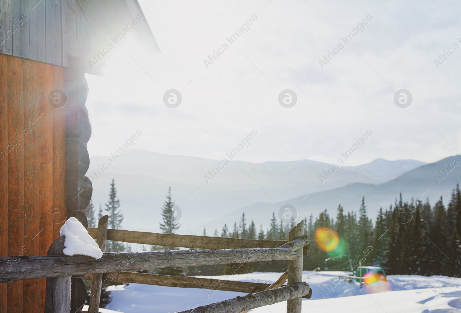 Photo of Wooden house in mountains on sunny day. Winter vacation