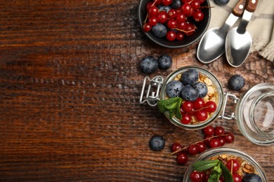 Photo of Delicious yogurt parfait with fresh berries and mint on wooden table, flat lay. Space for text