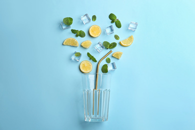 Photo of Creative lemonade layout with lemon slices, mint and ice on light blue background, top view