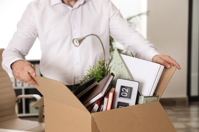 Young man with box of stuff in office, closeup