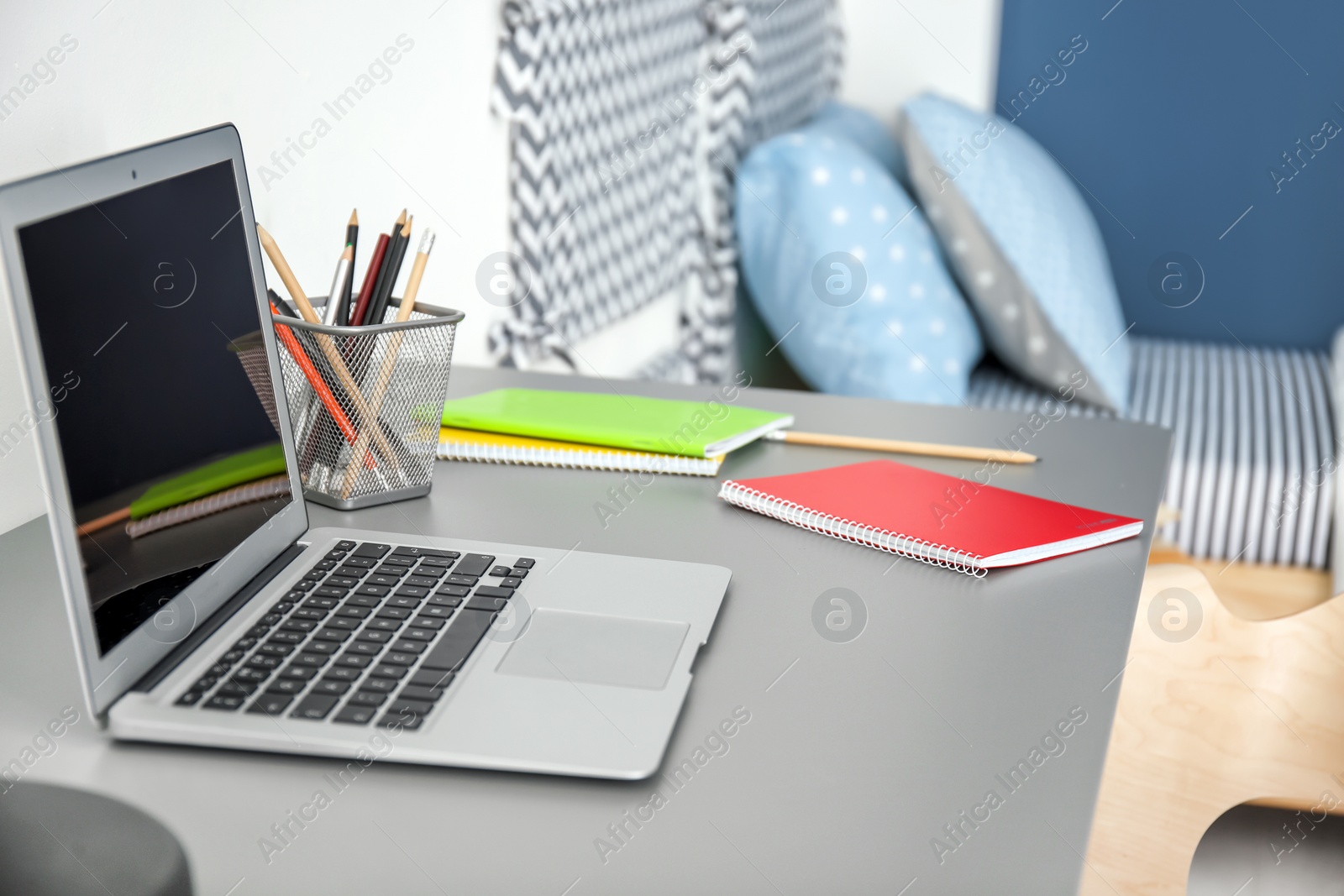 Photo of Comfortable workplace with laptop on desk in modern child room