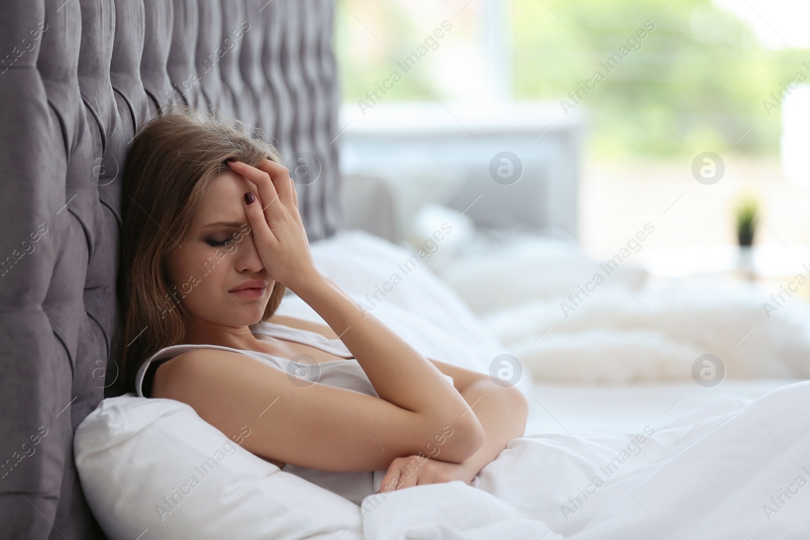 Photo of Depressed young woman in bed at home