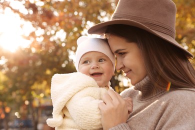 Photo of Happy mother with her baby daughter outdoors on autumn day