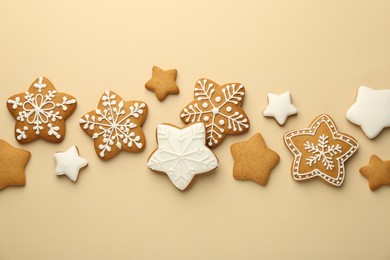 Photo of Tasty Christmas cookies with icing on beige background, flat lay