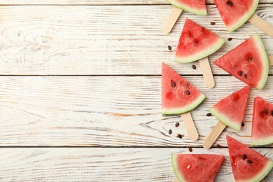 Photo of Slices of ripe watermelon on white wooden table, flat lay. Space for text