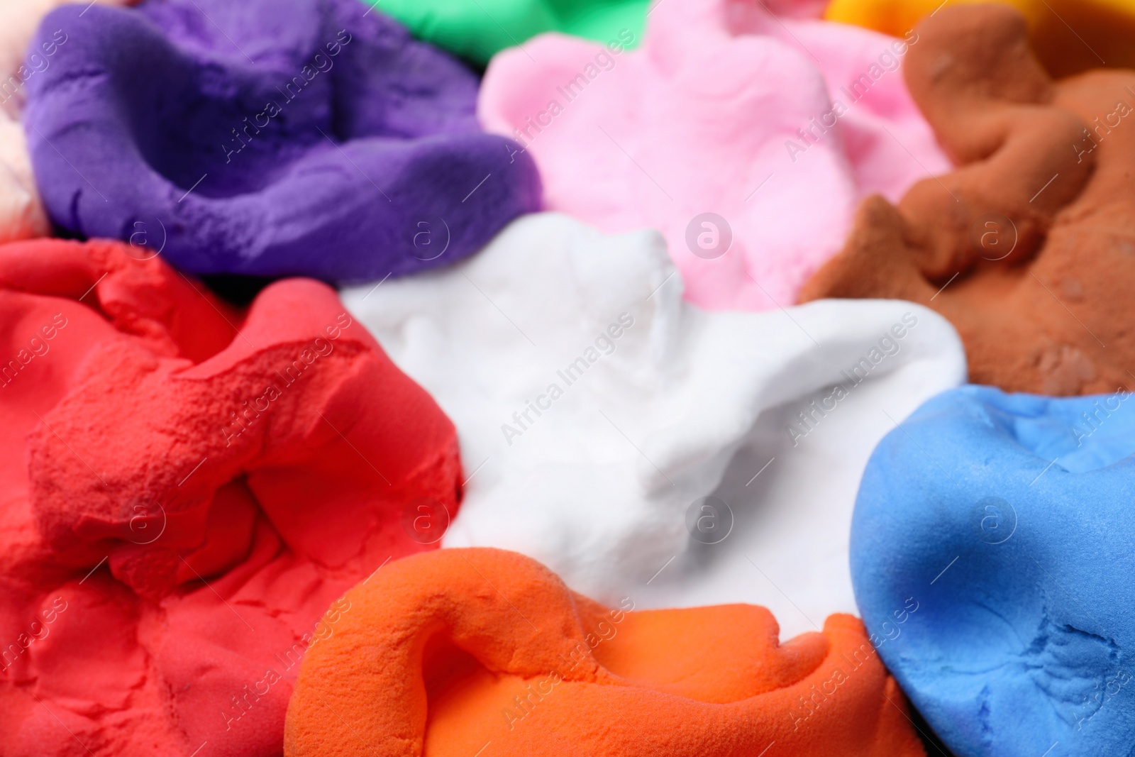 Photo of Pile of colorful plasticine as background, closeup