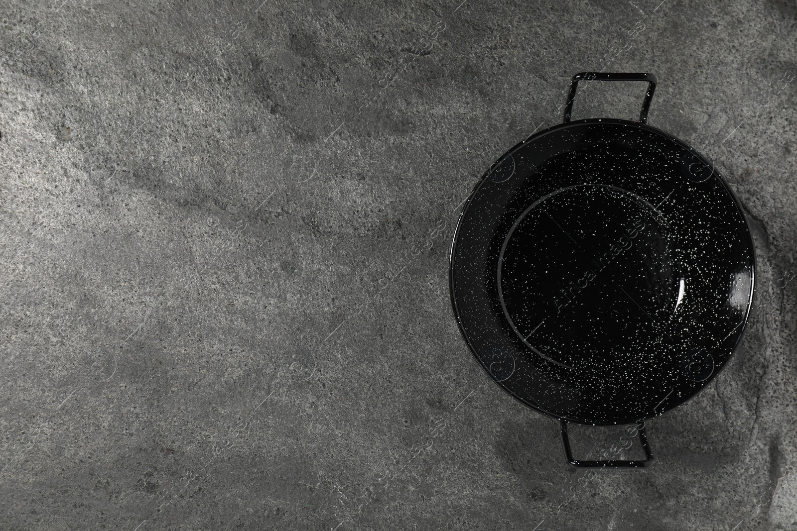 Photo of Empty iron wok on grey table, top view. Space for text