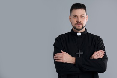 Photo of Priest with cross on grey background, space for text