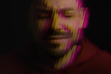 Man suffering from paranoia on black background, glitch effect