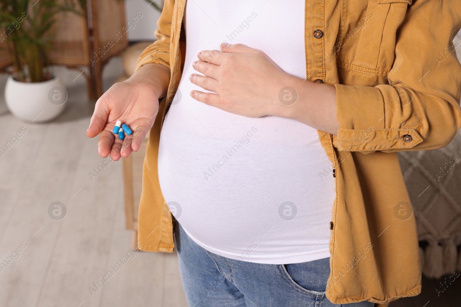 Photo of Pregnant woman taking pills at home, closeup