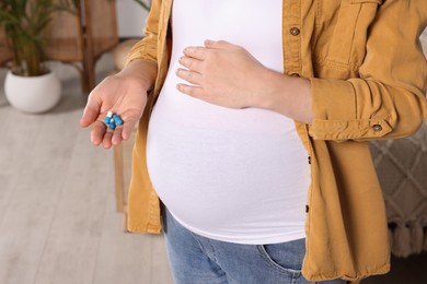 Photo of Pregnant woman taking pills at home, closeup