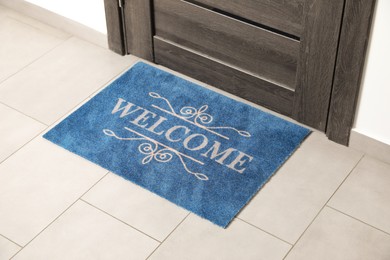 Photo of Beautiful doormat with word Welcome on floor near entrance