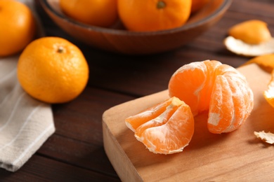 Photo of Fresh tangerines on wooden table. Citrus fruit