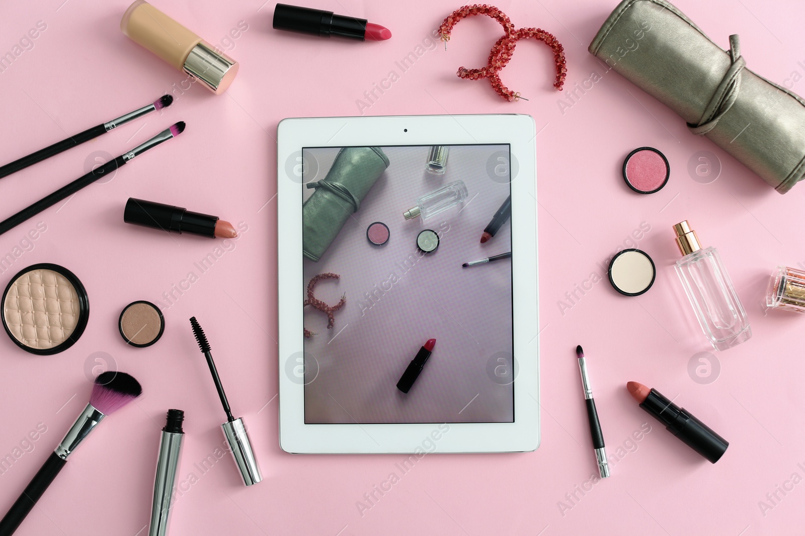 Photo of Makeup products for woman and tablet on color background, top view