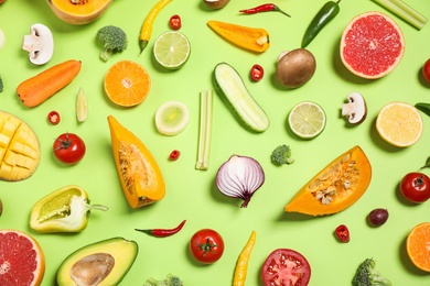 Photo of Flat lay composition with fresh organic fruits and vegetables on light green background