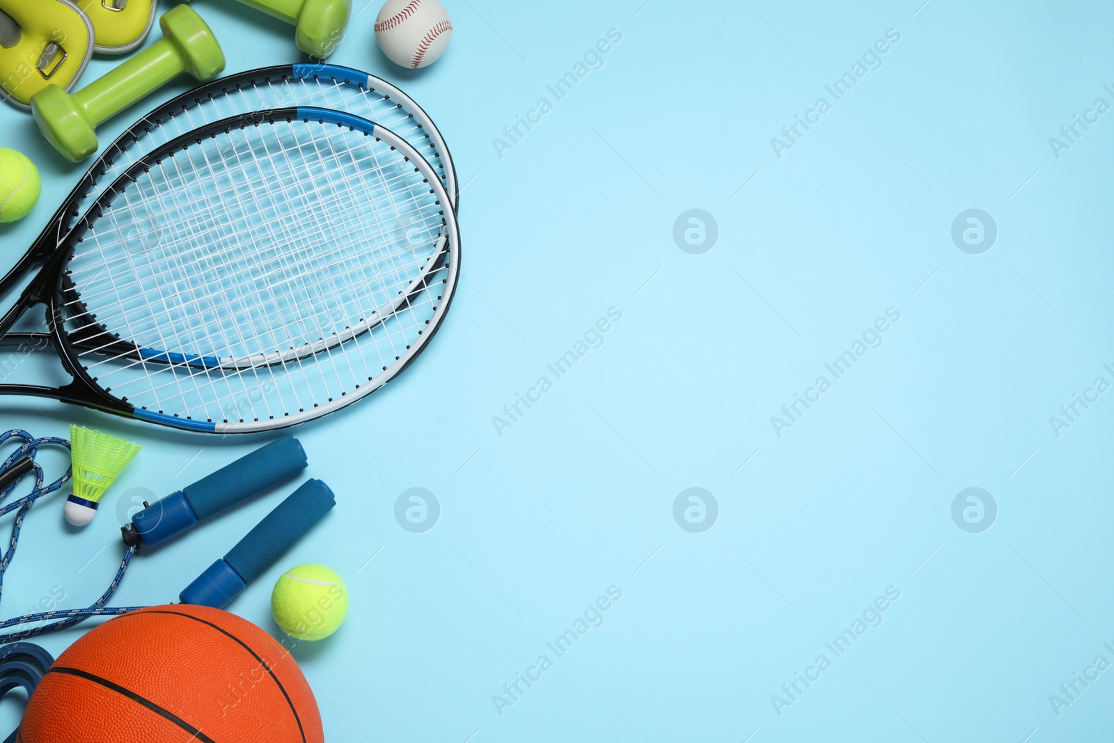 Photo of Set of different sports equipment on light blue background, flat lay. Space for text