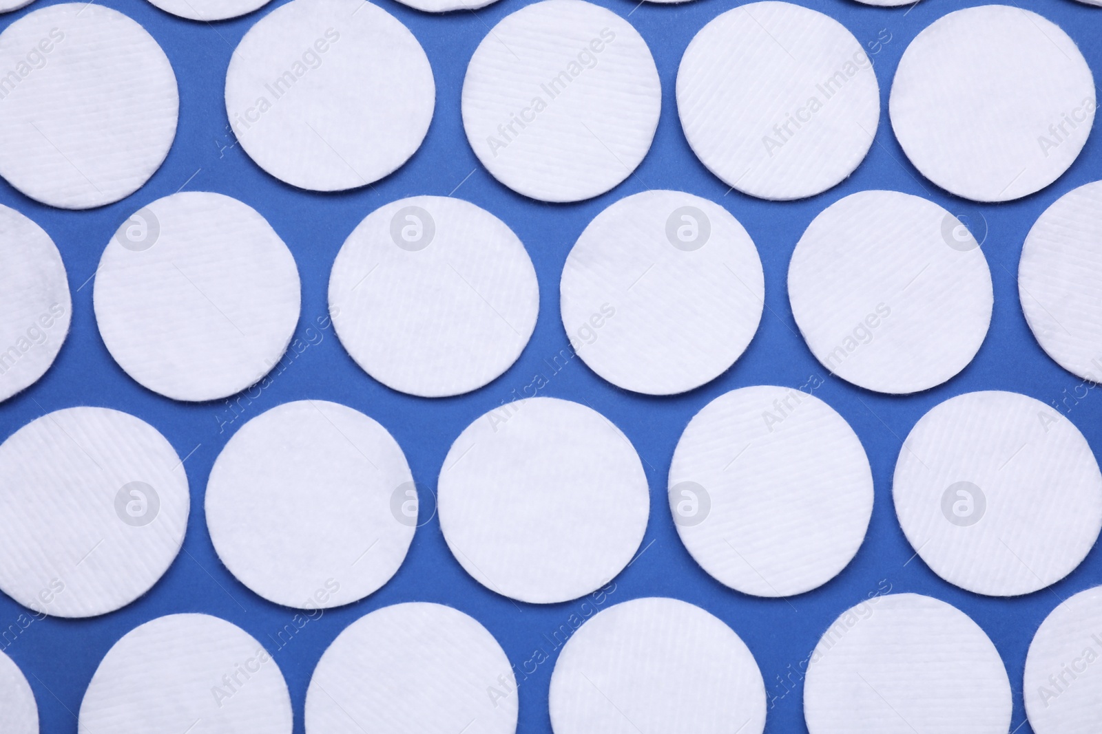 Photo of Many cotton pads on blue background, flat lay