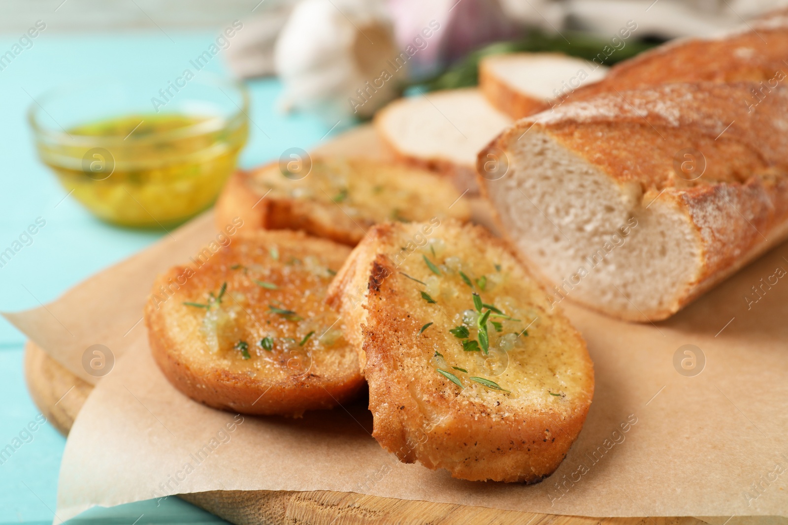 Photo of Slices of toasted bread with garlic and herbs on wooden board, closeup