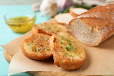 Photo of Slices of toasted bread with garlic and herbs on wooden board, closeup