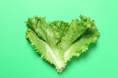 Leaves of fresh lettuce on green background, top view