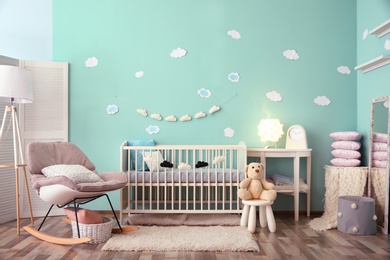 Photo of Modern baby room interior with crib and rocking chair